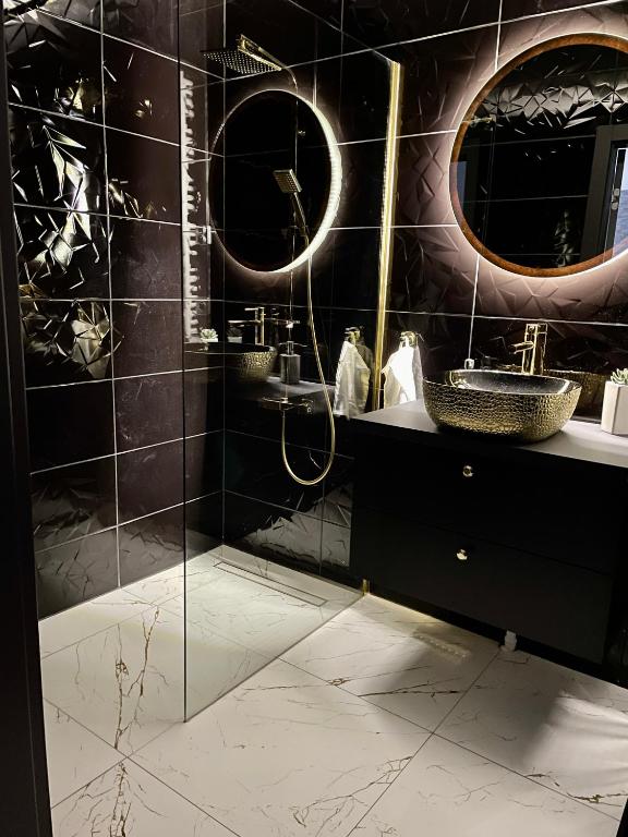 y baño con ducha, lavabo y espejos. en Apartament Drewnowska przy Manufakturze en Lodz