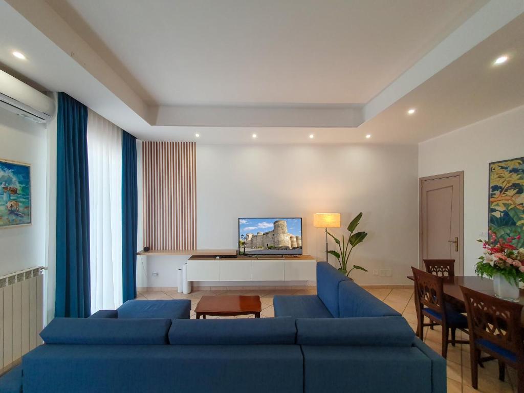 a living room with a blue couch and a table at Unico Gravina in Gravina di Catania