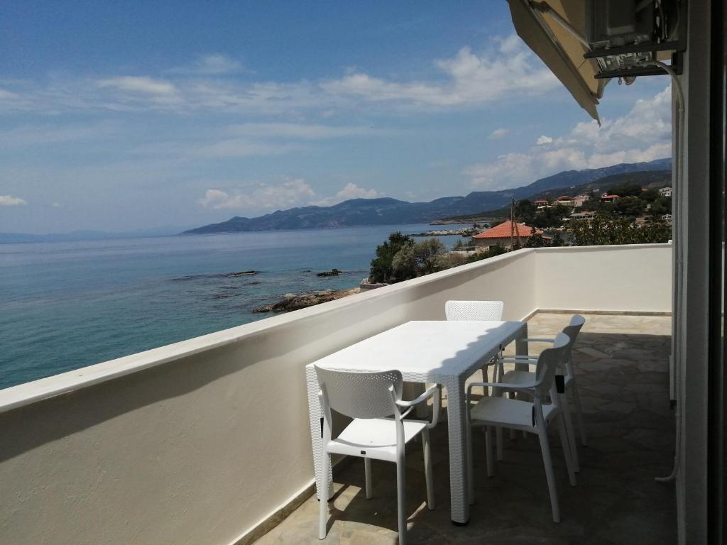 - stół i krzesła na balkonie z widokiem na ocean w obiekcie Filanthi CostaS w mieście Stoupa