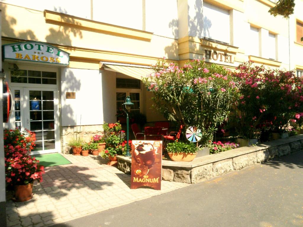 ein Blumenladen mit Blumen vor einem Gebäude in der Unterkunft Hotel Baross in Győr