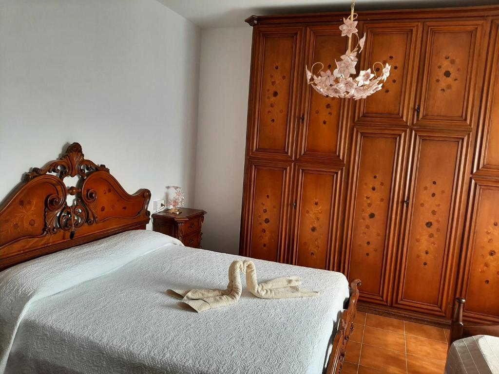 a bedroom with a bed with a wooden head board at LOCAZIONE TURISTICA ANNA in Porto Viro