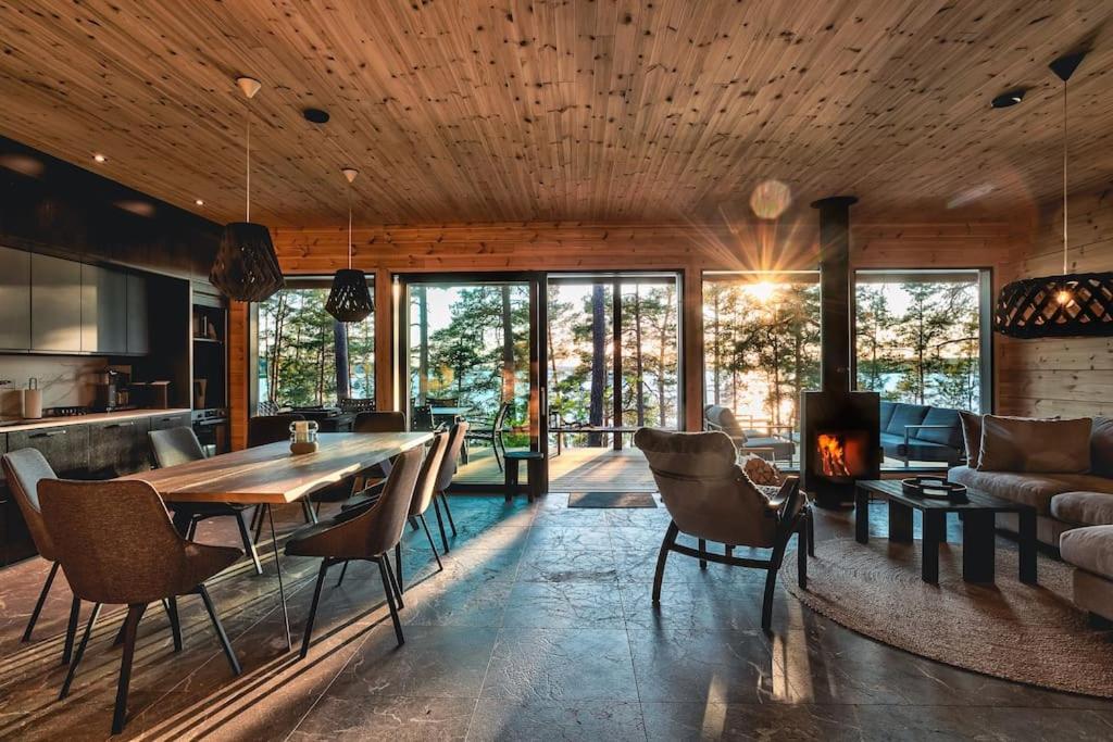 a kitchen and living room with a table and chairs at Saunamäki Resort - State of the Art Coastal Villa in Salo