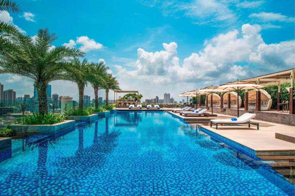 a pool on the roof of a building with palm trees at The St. Regis Mumbai in Mumbai