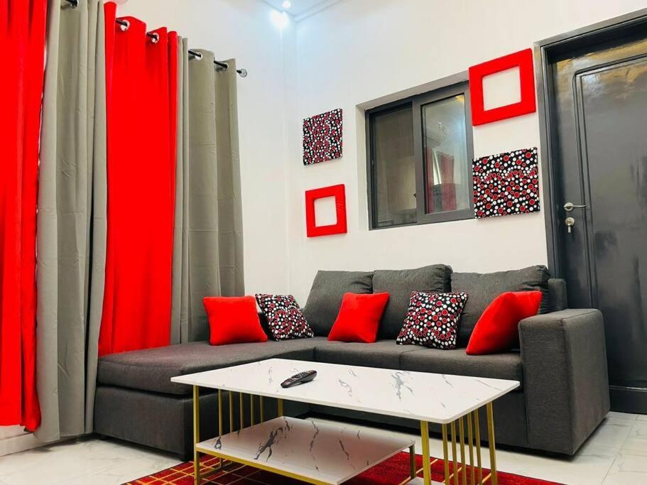 uma sala de estar com um sofá com almofadas vermelhas em Appartement T 2 N°2: Résidence LES 11 PLURIELLES 