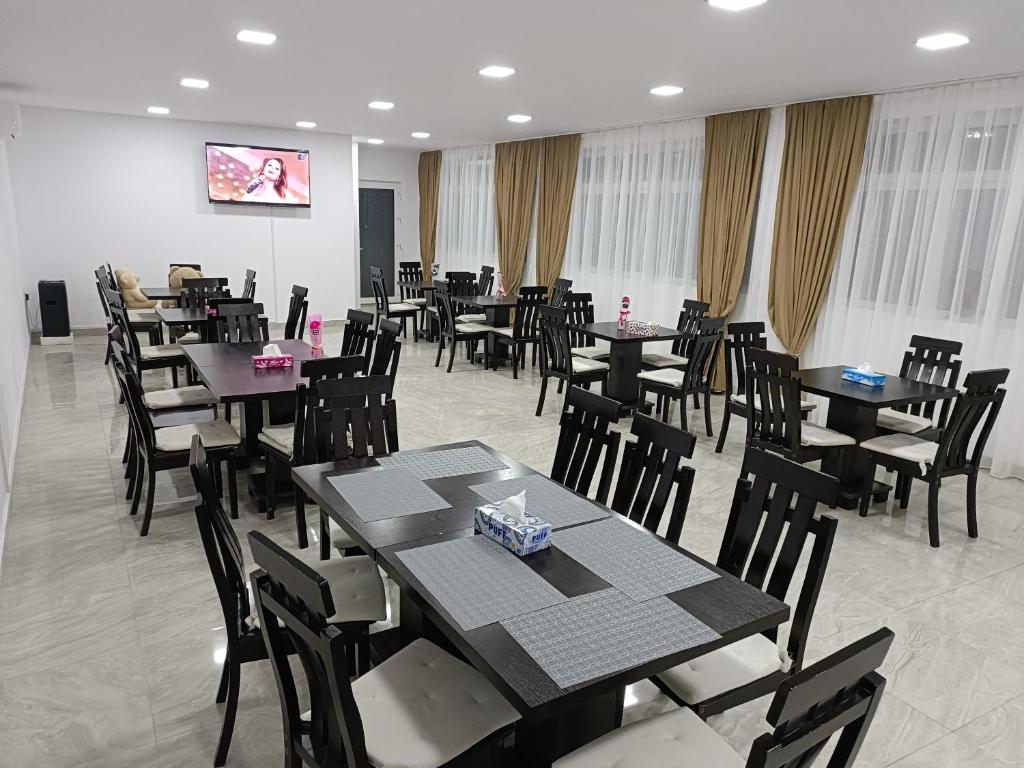 una sala da pranzo con tavoli e sedie di Casa Bianca Pensiune a Târgu Jiu
