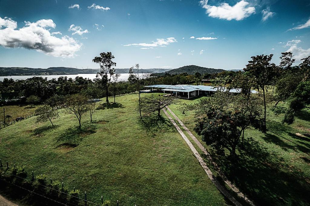 an aerial view of a building on a field with a lake at Hotel Little Paradise in Nuevo Arenal
