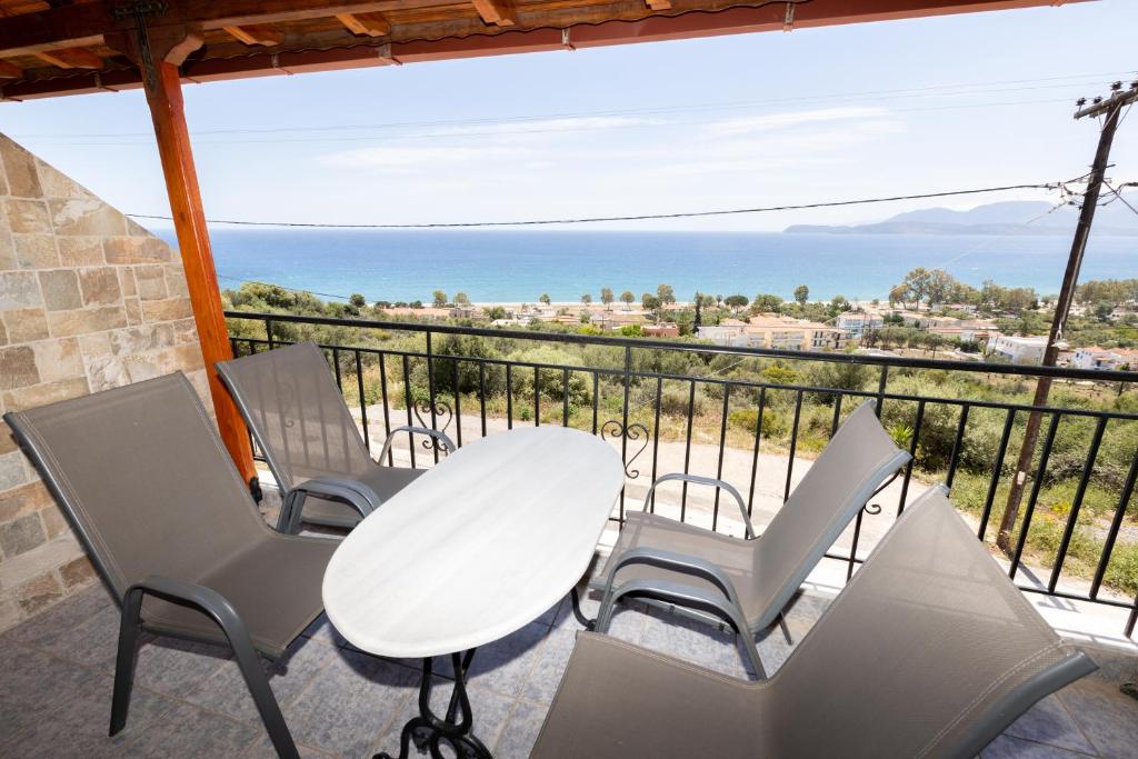 einen Tisch und Stühle auf einem Balkon mit Meerblick in der Unterkunft Αnastasia apartments in Mavrovouni