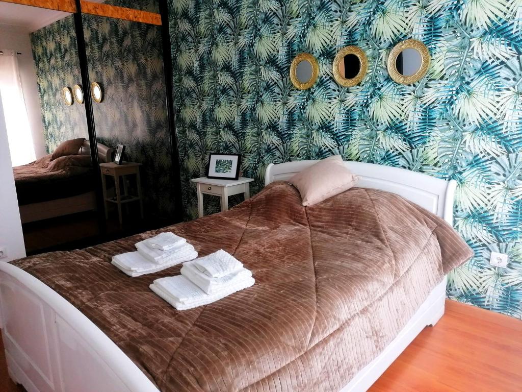 - une chambre avec un lit et des serviettes dans l'établissement Cocoon Guest House Vendas Novas, à Vendas Novas