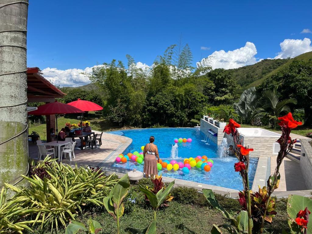 Monteverde Holiday Apartments في بوغا: امرأة تقف امام مسبح بالبالونات