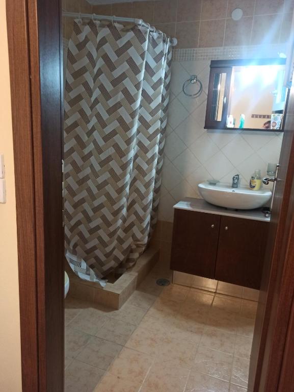 een badkamer met een wastafel en een douche bij Blondie's House in Evropoúloi