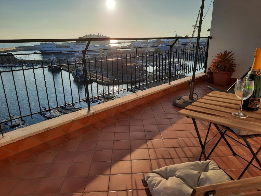 een balkon met een tafel en uitzicht op de oceaan bij MARE FUORI APARTMENT in Civitavecchia