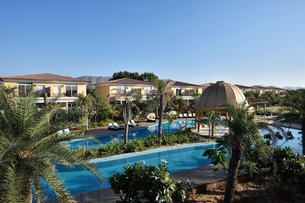 een luchtzicht op een zwembad van het resort met palmbomen bij The Westin Pushkar Resort & Spa in Pushkar