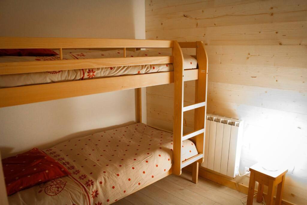 a bedroom with two bunk beds in a cabin at L'Écrin - Appartement au pied des pistes in Orcières
