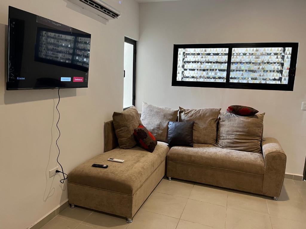 a living room with a couch and a flat screen tv at Departamento azinchite in Mazatlán