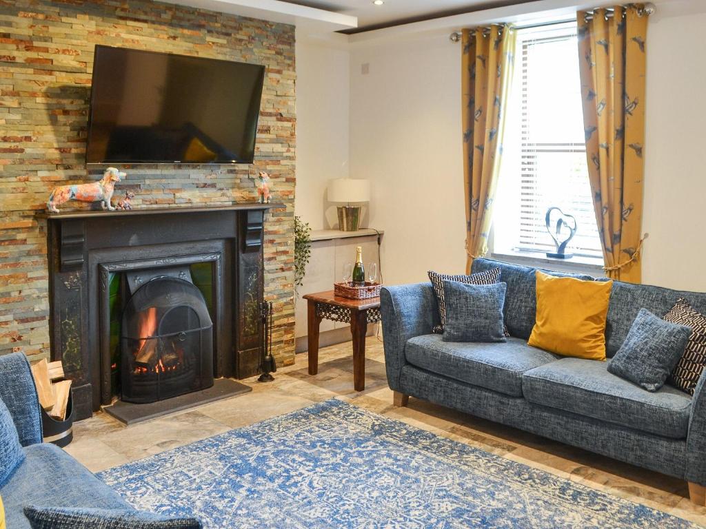 a living room with a couch and a fireplace at The Alnwick Townhouse in Alnwick