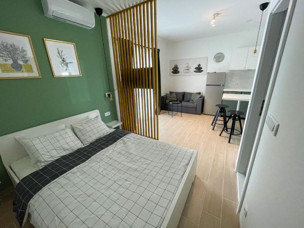 a bedroom with a bed and a living room at Modern studio overlooking downtown in Makarska