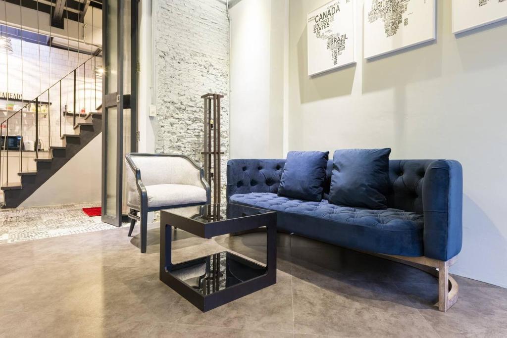 a blue couch and a chair in a room at Inner Old Town 196 Chic Guesthouse in Bangkok