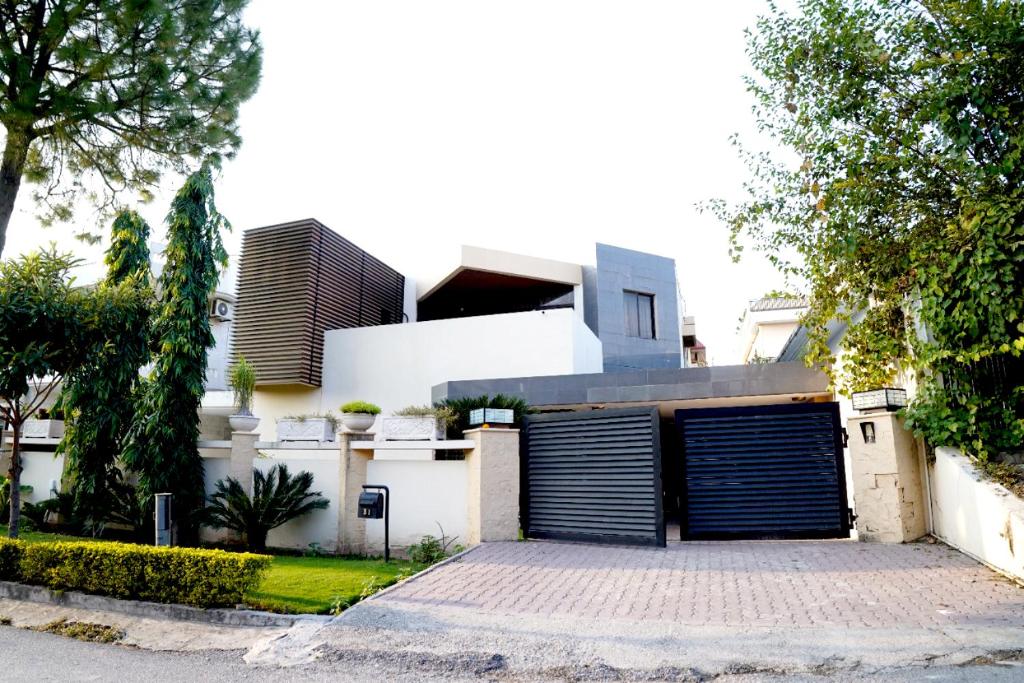 a white house with a large garage at Dream Inn Guest House in Islamabad