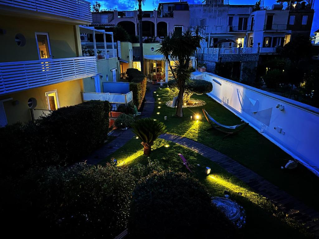 a garden with palm trees and lights at night at Marina 10 Boutique&Design Hotel in Ischia