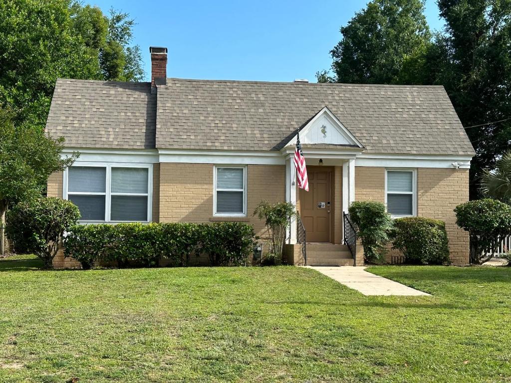 a house with an american flag in the yard at Calypso Pensacola in East Hill Neighborhood ! in Pensacola