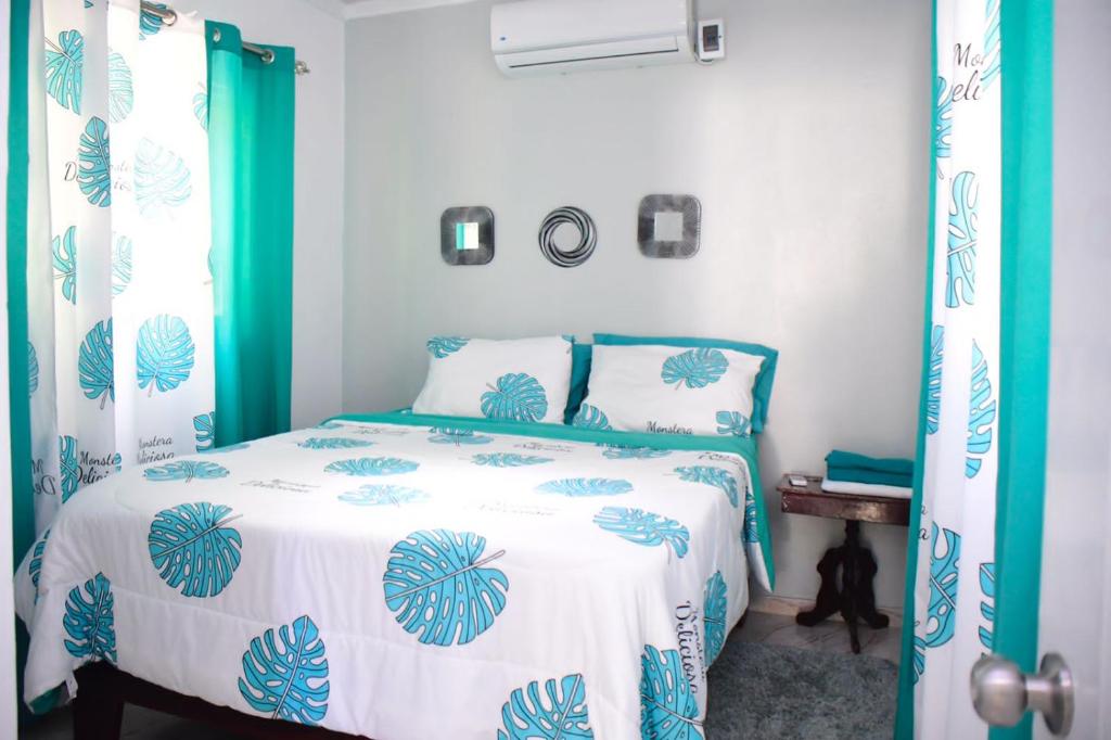 a bedroom with a bed with a blue and white comforter at Apartamento entero en Samaná Los tios in Santa Bárbara de Samaná