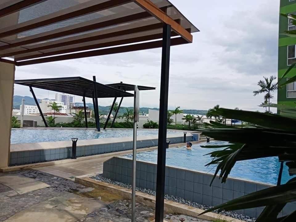 a swimming pool with an umbrella next to a building at 1 BR Centrio Tower 926 in Cagayan de Oro