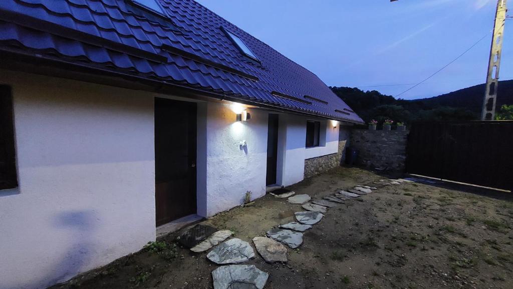 ein weißes Haus mit einem blauen Dach und einem Zaun in der Unterkunft Casa nouă in Sasca Montană