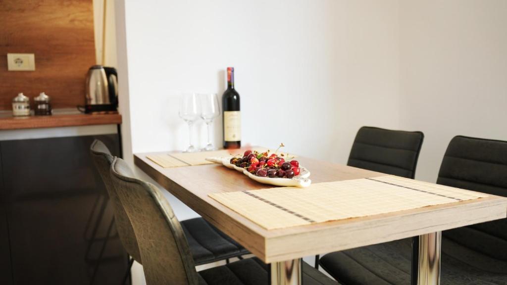 un tavolo con un cesto di frutta e una bottiglia di vino di High-Tech flat a Durrës