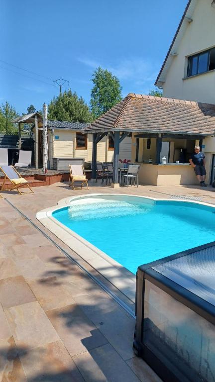 a large swimming pool in a yard with a house at La Pause Cauchoise in Vittefleur