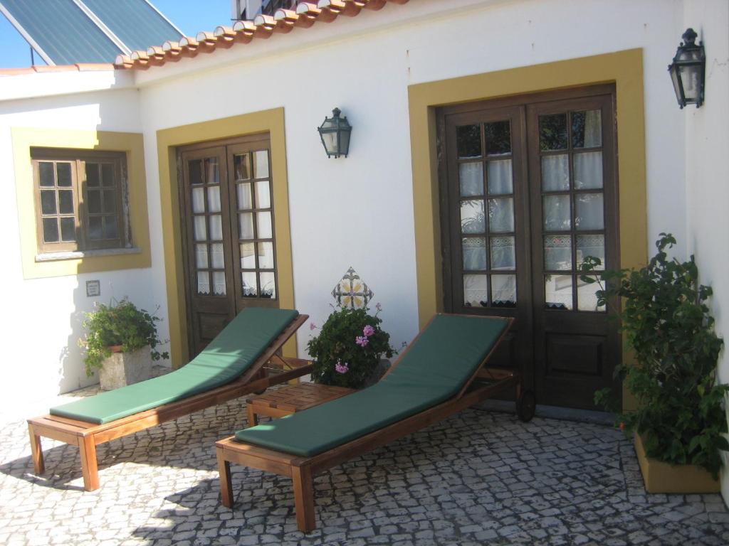 アレイア・ブランカにあるA Casinhaの家の前に長椅子2脚付きのパティオ