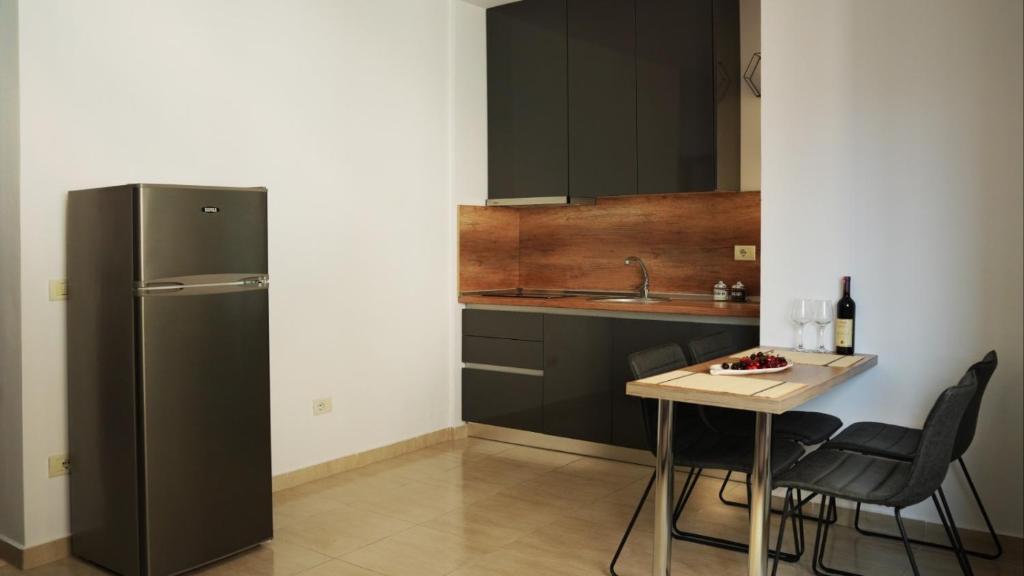 una cucina con frigorifero e tavolo con sedie di High-Tech flat a Durrës