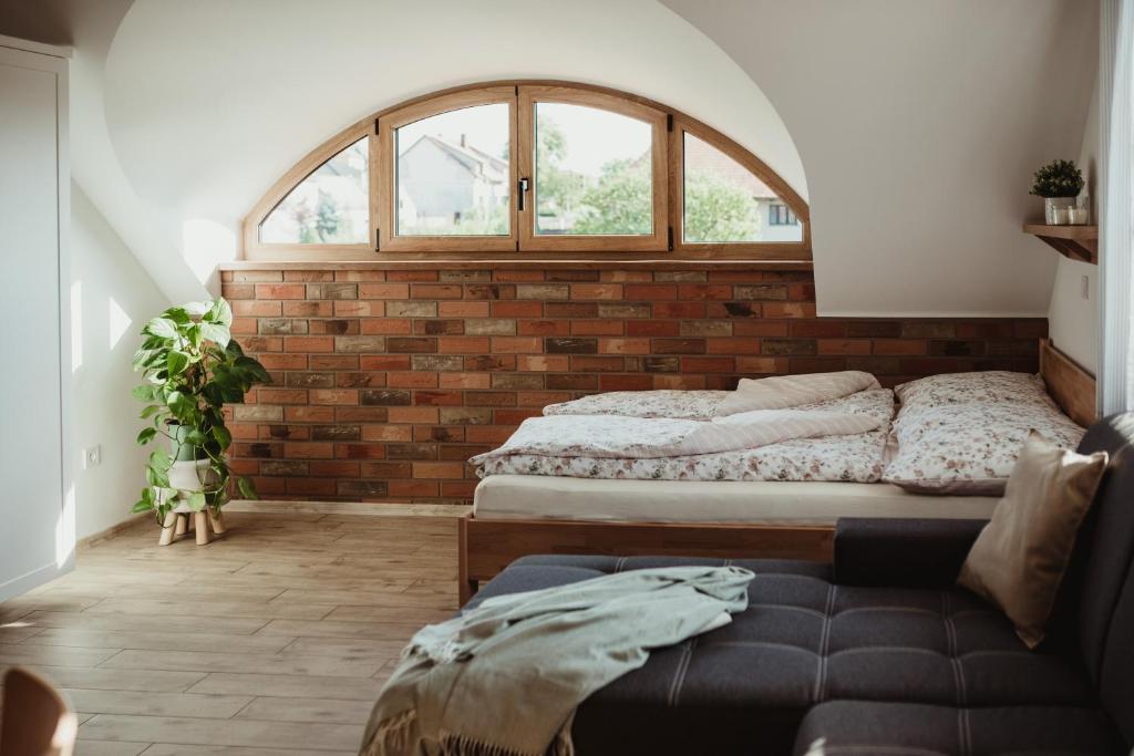 2 camas en una habitación con una pared de ladrillo en Apartmány Skoronice, 