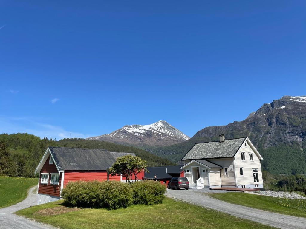 a house and a barn with mountains in the background at Høgset in Austefjorden