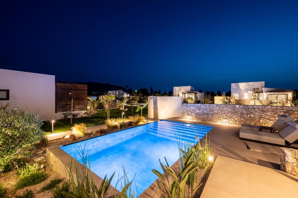 uma imagem de uma piscina à noite em Campo Premium Stay Private Pool Villas em Cós