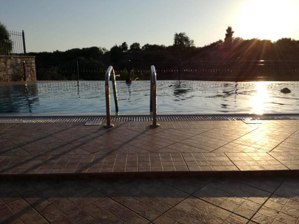 a swimming pool with the sun in the background at Villa Rodanthi Sivota in Syvota