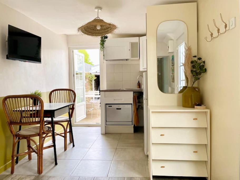 een keuken met een tafel en stoelen en een spiegel bij Maison centre bourg de Baden in Baden