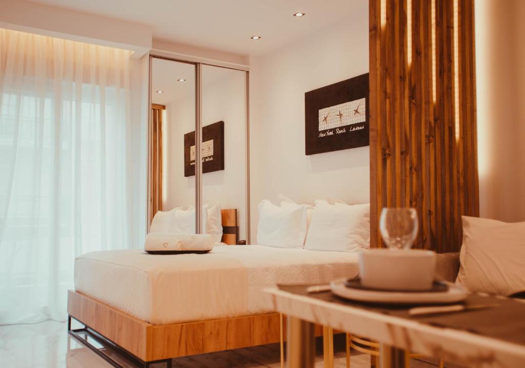 Schlafzimmer mit einem Bett, einem Tisch und einem Spiegel in der Unterkunft Aelia - Luxury Central Suite in Alexandroupoli