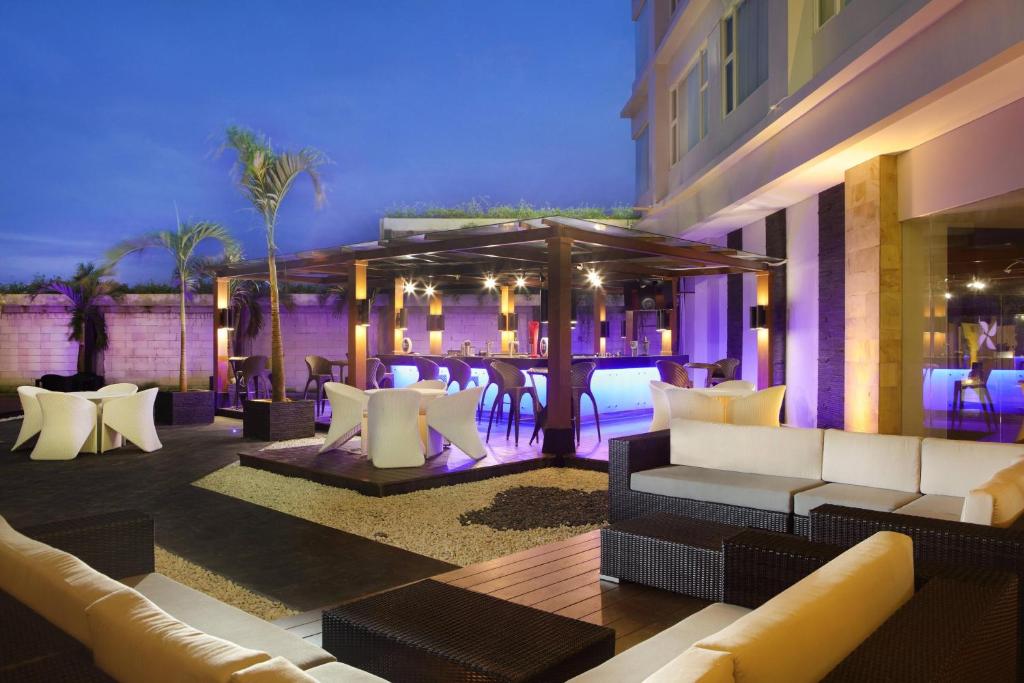 a patio with couches and a bar in a building at Four Points by Sheraton Manado in Manado