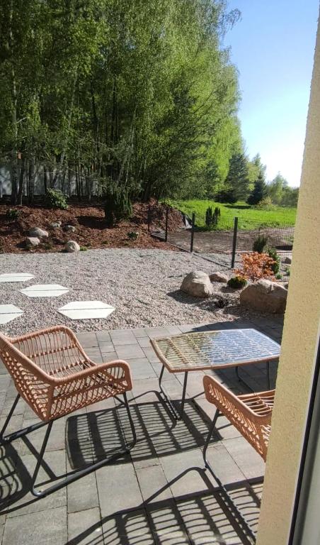 a patio with two chairs and a table at Stylowe apartamenty in Charzykowy