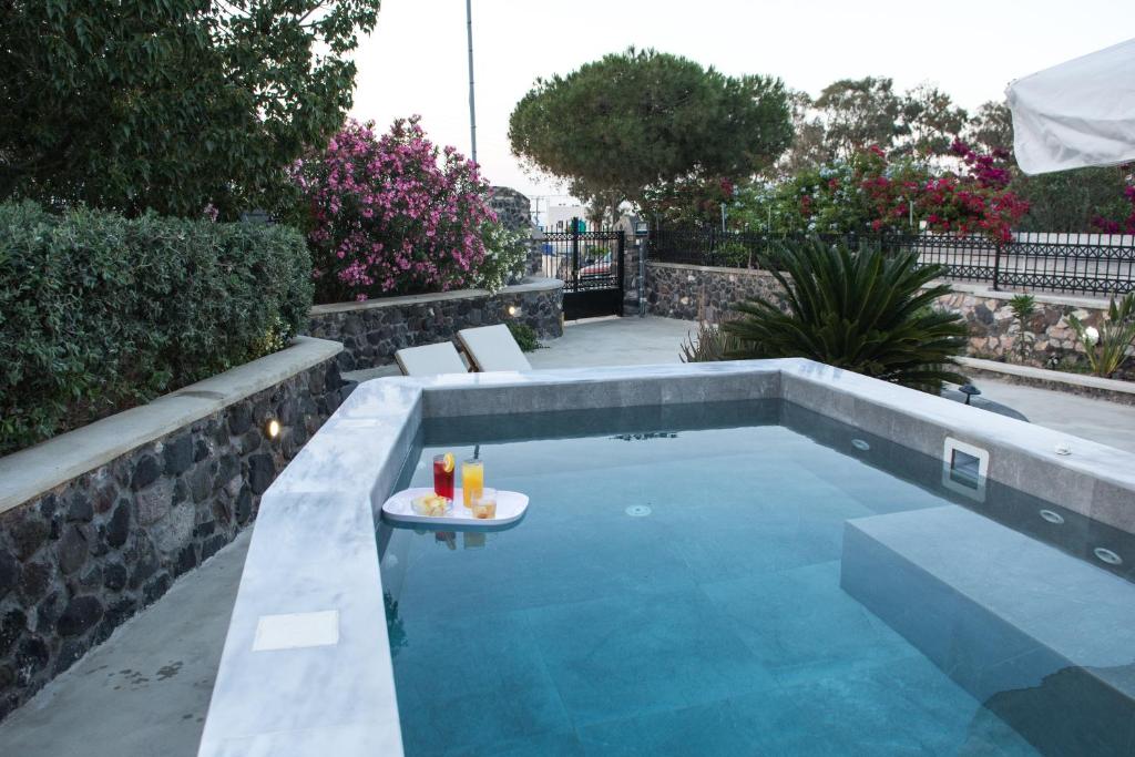 una piscina con un vassoio di bevande su un tavolo di Karpimo Vineyard Villa with Heated Pool a Éxo Goniá