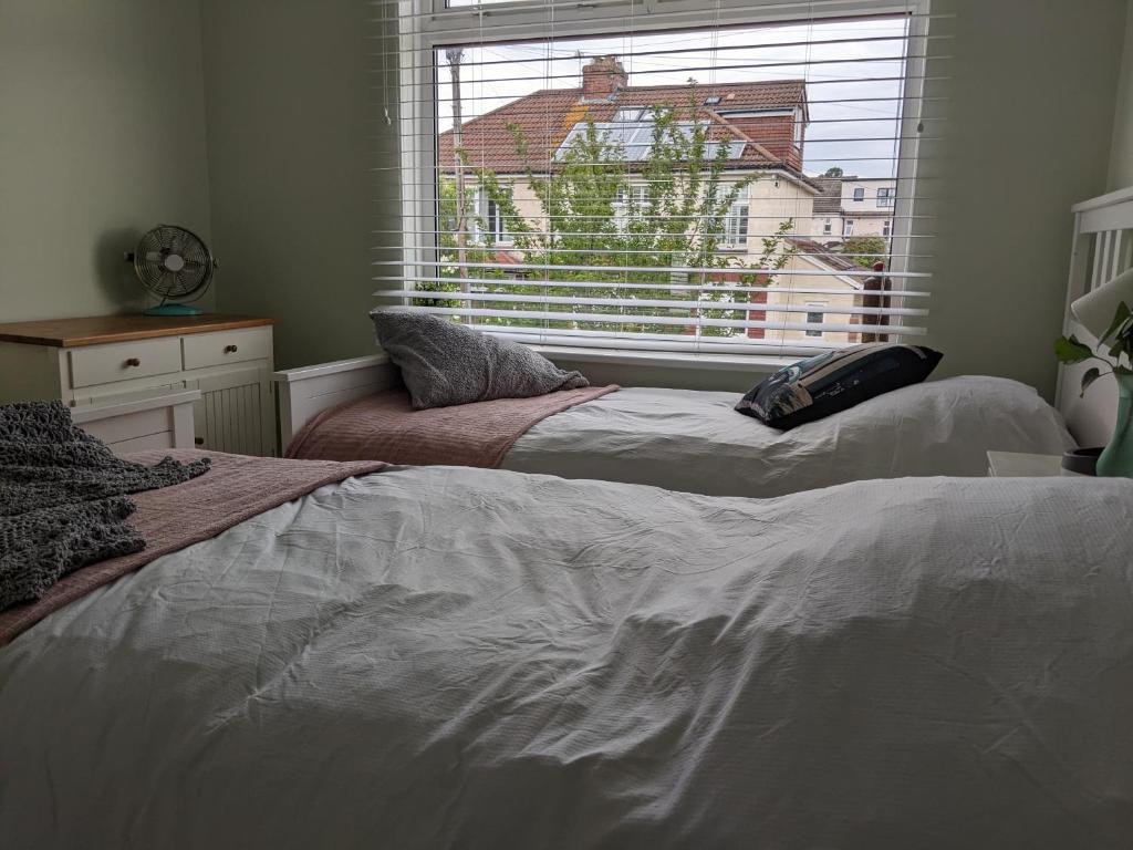 two beds sitting in a room with a window at The British Scooterist in Bristol