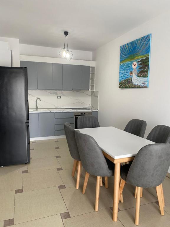uma cozinha e sala de jantar com mesa e cadeiras em Xh&S apartment em Durrës