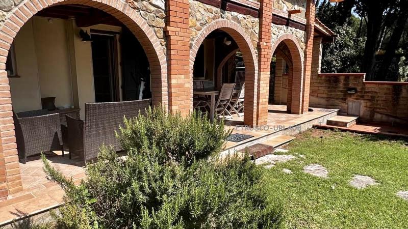 uma casa de tijolos com dois arcos e um pátio em Casa Piccolo Paradiso em Giuncarico