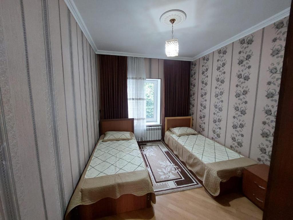 een kamer met 2 bedden en een raam bij Green Granden Vandam KMRN in Gabala