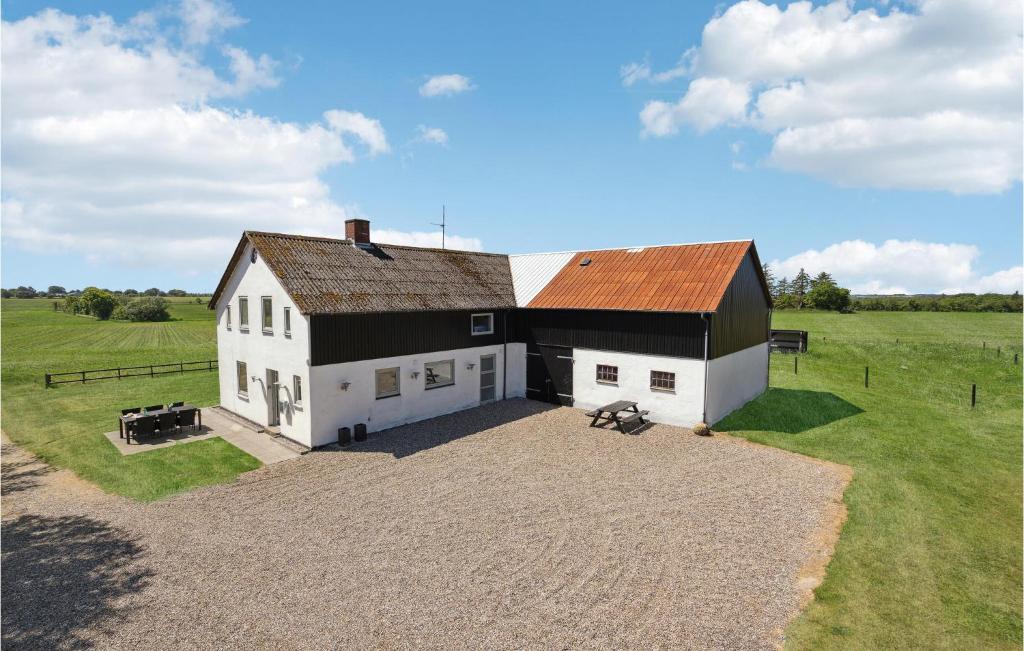 un granero grande blanco y negro en un campo en Cozy Home In Skrbk With Kitchen en Skærbæk