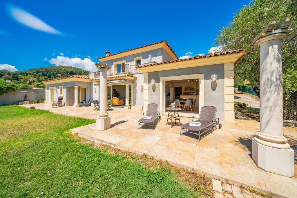 Cette maison dispose d'une terrasse avec deux chaises et une table. dans l'établissement Villa Super Cannes, à Vallauris