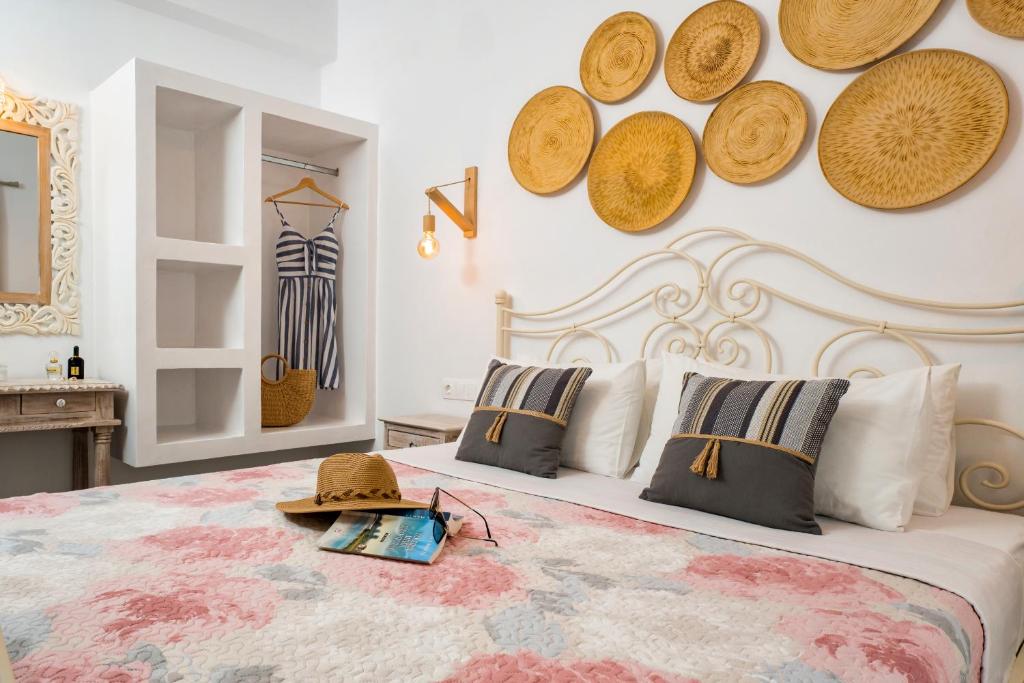 een slaapkamer met een bed met hoeden aan de muur bij Cozy little house in Ios in Ios Chora