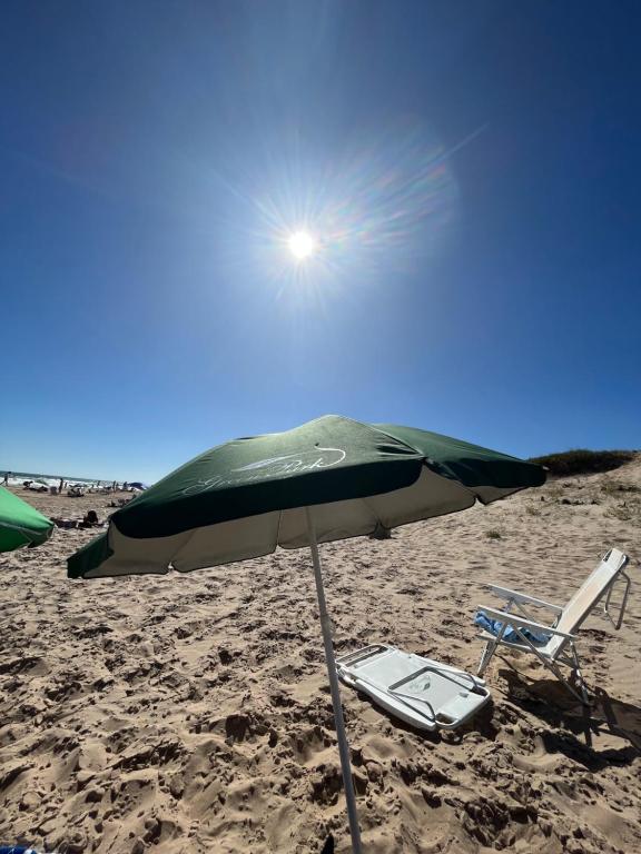 una silla y una sombrilla en una playa en Monoambiente Green Park- Solanas, en Punta del Este