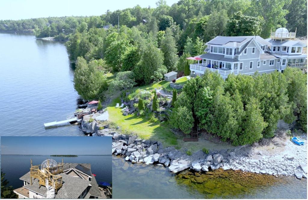 an aerial view of a large house on an island in the water at Loza house adirondack skydeck unit lake front in Plattsburgh