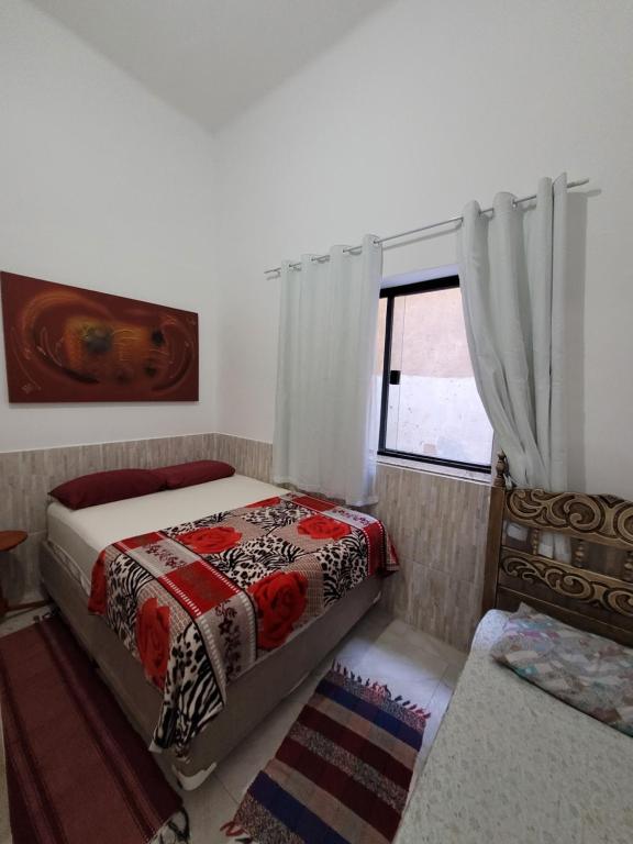 a bedroom with two beds and a window at Pousada Diniz in Resende